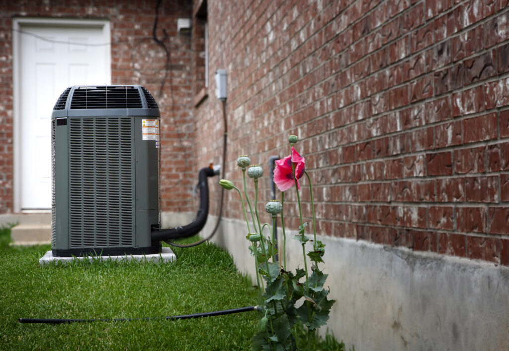 Side view of air conditioner with a flower in the foreground