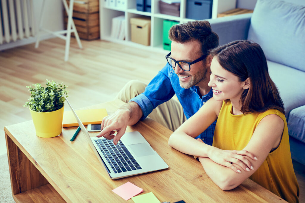 Smiling couple looking at a laptop screen