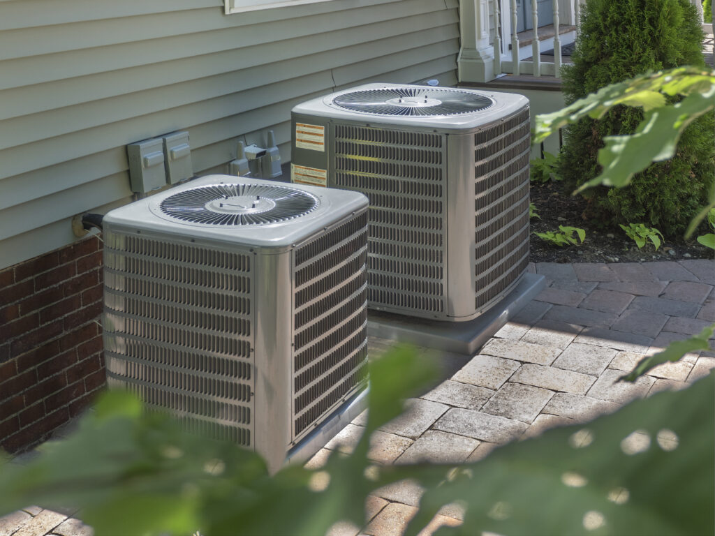 Two air conditioning units outside a home
