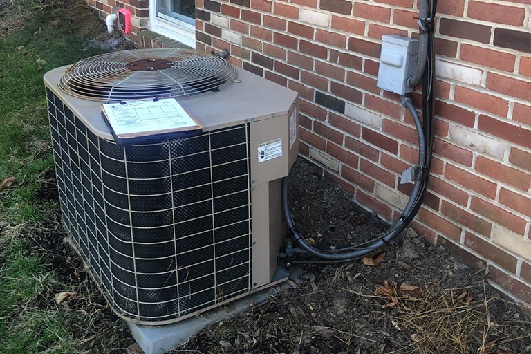 HVAC unit outside a brick home.