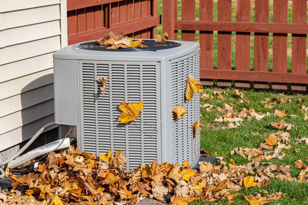 Outdoor heat pump covered in leaves