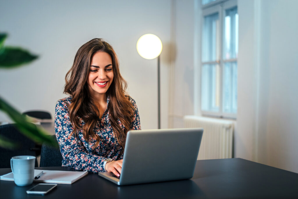 Smiling woman looking at her laptop