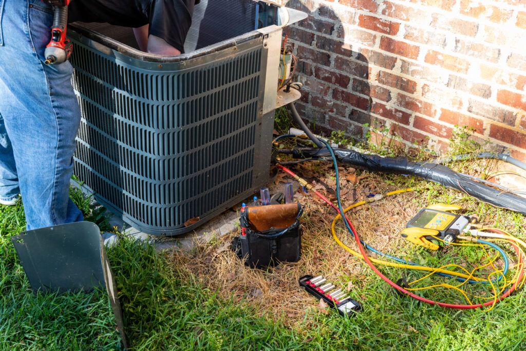 HVAC technician performing preventative AC maintenance
