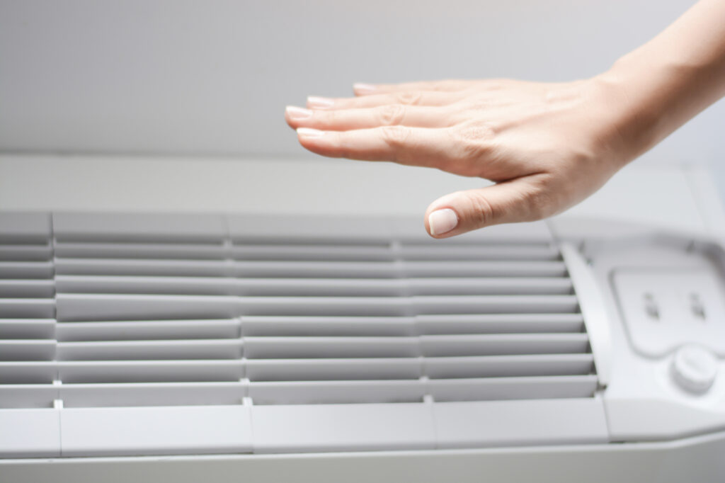 Hand hovering over a ductless mini-split